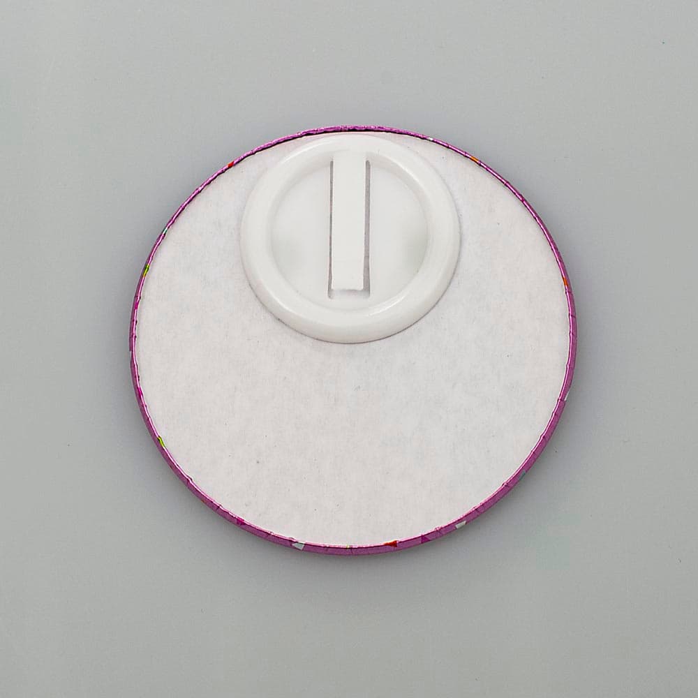 THIS ITEM IS A ROUND BADGE MEASURING 85MM IN DIAMETER WITH "IT'S MY BIRTHDAY" PRINTED ON IT. THE BADGE IS MADE OF TIN AND IT IS MOUNTED ONTO 1.5MM THICK WHITE LINED GREYBOARD ATTACHED TO WHICH IS A PLASTIC CLIP SO BADGE CAN BE ATTACHED TO CLOTHING. THE FRONT HAS A COVER OF POLYETHYLENE FOIL WITH METALLIC PAINT APPLIED TO IT.