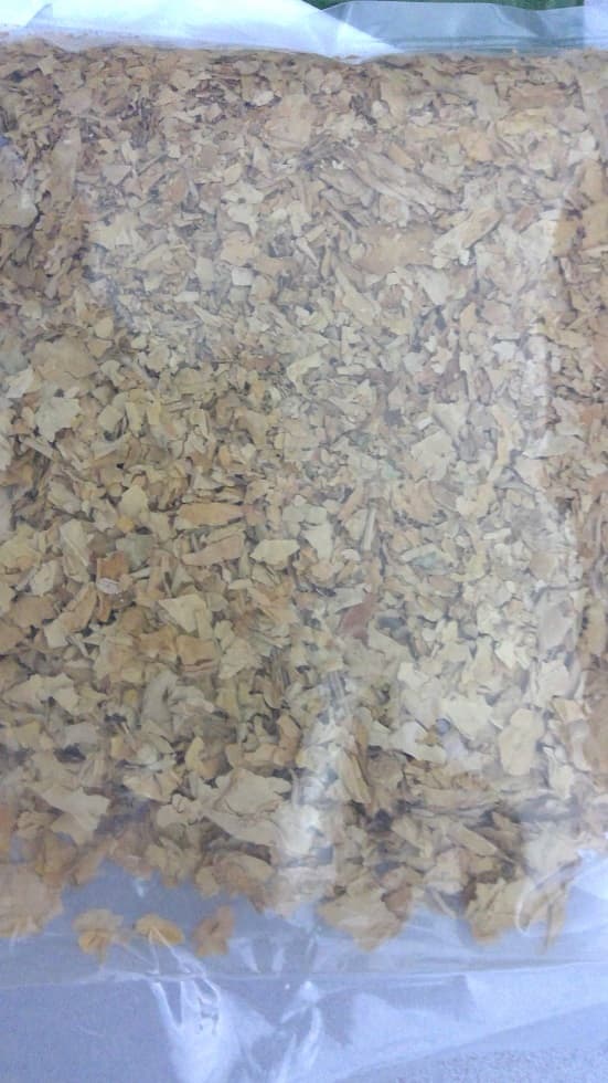 SUN CURED TOBACCO IN 225 GRAMME PLASTIC BAGS. IT HAS NOT HAD ANY INDUSTRIAL OR MANUFACTURING PROCESS, AND REQUIRES FURTHER PROCESSING BEFORE IT CAN BE USED. IT IS IN THE FORM OF SMALL FLAKES, MAINLY LIGHT BROWN IN COLOUR