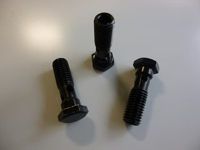 A THREADED CROSS DRILLED BANJO BOLT WITH A HEXAGONAL HEAD. MANUFACTURED FROM JIS G3507 GRADE SWRCH15A CARBON STEEL AND IS USED IN THE MANUFACTURE OF HYDRAULIC PRESSURE VALVES. IT HAS A TENSILE STRENGTH OF 340N/M2.