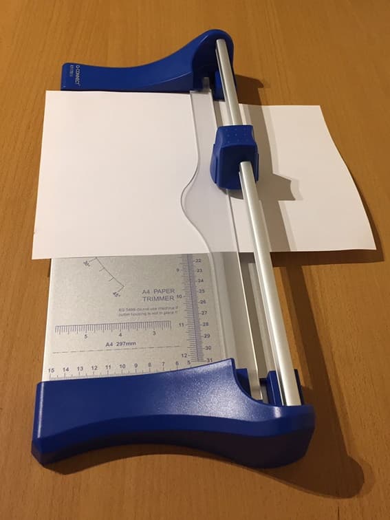 AN A4 PAPER TRIMMER WHICH USES A GROUND ROTARY CUTTING BLADE WITHIN A PLASTIC CASING. THE BASE FEATURES A PRINTED GRID WITH STANDARD PAPER SIZES FOR ACCURATE TRIMMING. THE A4 TRIMMER HAS A CUTTING LENGTH OF 320 MM. IT IS DESIGNED TO BE PLACED ON A TABLETOP AND THE BLADE IS MANUALLY PUSHED ACROSS THE PAPER TO CUT IT TO THE REQUIRED SIZE.
