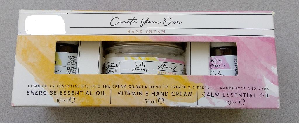 CREATE YOUR OWN HAND CREAM SET CONSISTING OF VITAMIN E HAND CREAM WITH INDIVIDUAL ENERGISE ESSENTIAL OIL AND CALM ESSENTIAL OIL, ALLOWING YOU TO COMBINE AN ESSENTIAL OIL INTO THE CREAM ON YOUR HAND TO CREATE TWO DIFFERENT FRAGRANCES. TO USE PUT A PEA SIZE AMOUNT OF CREAM ONTO YOUR HAND AND ADD 1 - 2 DROPS OF YOUR CHOSEN ESSENTIAL OIL, THEN MASSAGE INTO YOUR SKIN. ENERGISE OIL CONSISTS OF GRAPEFRUIT, LEMON AND ROSEMARY. CALM OIL CONSISTS OF YLANG YLANG, PATCHOULI AND FRANKINCENSE. THE HAND CREAM GENTLY MOISTURISES AND HYDRATES YOUR HANDS. CREAM IS IN A 50 ML JAR, THE ESSENTIAL OILS ARE IN 10 ML BOTTLES. PACKAGED IN A COLOURFUL CARDBOARD BOX.