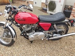 1974 NORTON-VILLIERS COMMANDO.

2 WHEELED MOTORCYCLE. DESIGNED TO TRANSPORT 2 PERSONS. 850CC PETROL ENGINE, AIR-COOLED OVERHEAD VALVE (OVH) PARALLEL-TWIN TOP SPEED 115 MPH (185 KM/H) (750) 4 SPEED CHAIN TRANSMISSION. BODY COLOUR IS RED, BLACK AND CHROME.

THE MODEL IS NO LONGER IN PRODUCTION.