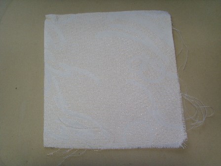 Tkani tekstilni materijal s uzorkom, izrađen od pređa različitih boja, mase 194 g/m2, s masenim udjelom sintetičkih filamenata većim od 85 %. U svrhu povećanja čvrstoće tkanina je impregnirana apreturom koja sadrži ljepilo (nije vidljivo golim okom). Tkanina je namijenjena za izradu navlaka za madrace. Isporučuje se u svicima širine 215 cm.