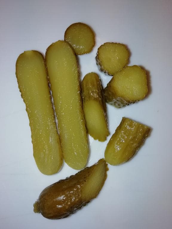 A termék kb. 5 cm hosszúságú, élénk zöld színű, kemény, ropogós, savanyú illatú, savanyú- sós ízű, apró egész uborkák, enyhén opálos, halványsárga színű, savanyú illatú, savanyú-sós lében, mely egyéb fűszereket nem tartalmaz. Az uborkák keresztmetszete élénk színű, nem üvegszerű, nem áttetsző. 
Az elvégzett vizsgálatok szerint a termék sótartalma 3,9 m/m %, savtartalma 3,2 m/m %, tejsav tartalom 0,1 g/l, cukortartalom: fruktóz 0,7 m/m %, glükóz 0,6 m/m %, szacharóz, maltóz, laktóz nem mutatható ki.
A terméket további feldolgozás után – sótartalom eltávolítás (vízcserés technológiával), konzervüvegbe/dobozba töltés, új felöntőlé hozzáadása (ízesítés), konzerv lapka felhelyezés/doboz fedő felhelyezése után hőkezeléssel (pasztőrözés) tartósítják, végül címkézés – kiskereskedelmi forgalomba bocsátják.
A termék uborkából, valamint felöntőléből (víz, só, ecetsav) áll.
Hordóban kiszerelve érkezik.