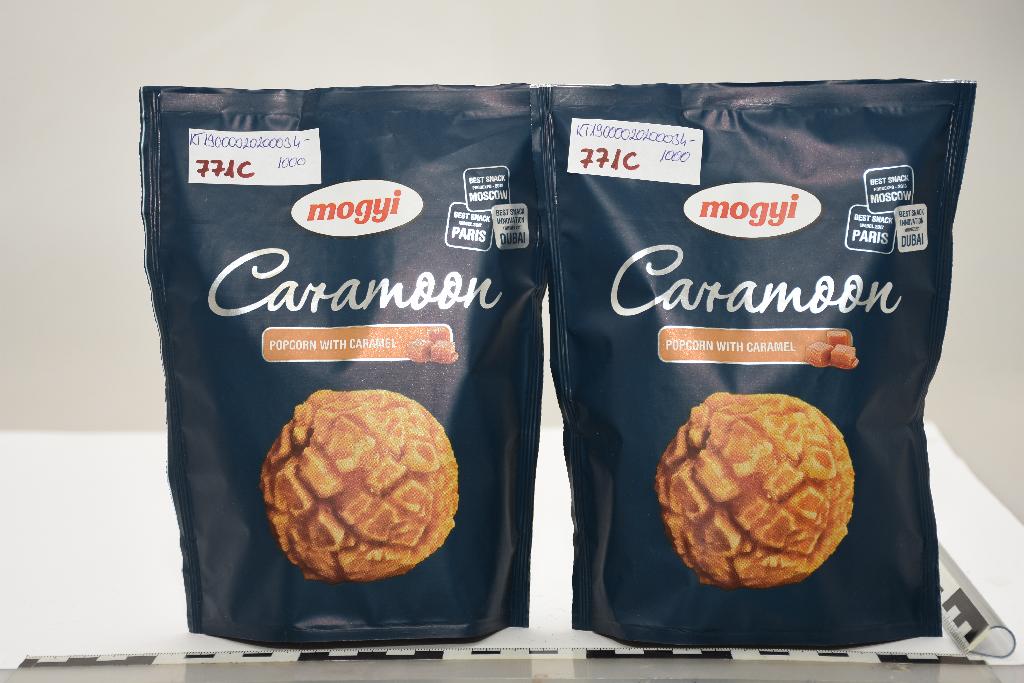 A KTF kérelemhez megküldött minta 70 g-os kiskereskedelmi kiszerelésben, fóliahegesztéssel lezárt műanyag tasakban, védőgázas csomagolásban, bontatlanul érkezett. 
Az elvégzett érzékszervi vizsgálat alapján a minta alapját sárgás-fehér színű, barnás színű maghéj résszel rendelkező, különböző méretű (átlagosan kb. 2 x 1,5 x 1,5 cm-es), könnyű, levegős, de roppanós, pattogatott kukoricára jellemző szerkezetű termék adja, amelynek felszínét részben, vékony rétegben egy barnás színű, édes, karamellás jellegű, ridegre dermedt mázzal vontak be. A minta édes, karamellás, pattogatott kukoricára jellemző illatú és ízű termék.
A termék felhasználását tekintve közvetlen emberi fogyasztásra szolgáló élelmiszer.
Termékösszetétel a kérelemben feltüntetett információk szerint %-ban megadva: 
-pattogatott kukorica: 19,54 %
-cukor: 53,48 %
-glükóz szirup: 18,51 %
-étkezési só: 0,82 %
-toffee aroma: 0,35 %
-vaj: 6,85 %
-szójalecitin: 0,31 %
-karamell szirup: 0,14 %
Az elvégzett érzékszervi vizsgálat, valamint a csomagoláson feltüntetett információk alapján, a termék kiskereskedelem számára kiszerelt, közvetlen fogyasztásra alkalmas. Az összetételi információk alapján a termék cukortartalma magas, azonban a minta kizárólag vékony karamell réteggel került részben, ízesítés céljából bevonásra, melyet az érzékszervi vizsgálat is alátámaszt. A bevonat a terméket nem borítja be teljesen, illetve annak vastagság sem eredményez cukorkaáru jelleget a terméknek, így a termék karamellás ízesítésű pattogatott kukoricának minősül.
