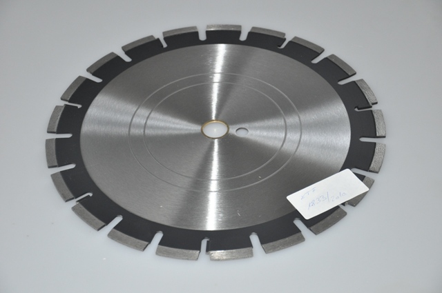 Gyémántszegmenses vágótárcsa (diamond blade, Diamant-Trennscheibe)Felhasználása: elsősorban építőanyagok (aszfalt, beton, tégla, burkoló anyag) vágása, darabolása.
Érzékszervi vizsgálat: a minta fémből készült, 35,0 cm átmérőjű, kör alakú vágótárcsa, amelynek a közepén 2,6 cm átmérőjű lyuk van és a szélén 1 cm széles, szürke színű peremmel rendelkezik. A peremen apró szemcsés, fénylő berakások vannak, amelyek az üveget karcolják. A peremen 21 db, szimmetrikusan elhelyezkedő V alakú bevágás van, amely a minta középső részén egy U alakú bevágásban végződik a peremtől 1,7 cm-re. A mintán a perem és a lyuk közötti részen a 2,5 cm széles, feketére festett sáv van és a többi terület szürke színű, ezen helyezkedik el egy 1,3 cm átmérőjű lyuk. A külső, berakásos szegmens nélkül a termék nem képes ellátni a vágó funkciót. A mintán olvasható szám: 32686.
A jogosult nyilatkozata szerint a vágófelület fémkötésű szintetikus gyémántszemcsékből áll. A vágófelületet az alaptestre lézerhegesztéssel rögzítik. A cég által  forgalmazott mérettartomány átmérő 300 mm-900 mm között van.