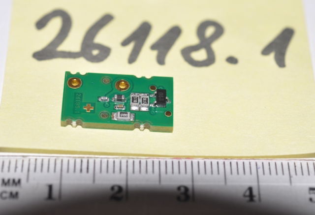 A jogosult nyilatkozata alapján a termék felületszerelt PCB amely aktív és passzív alkatrészeket tartalmaz. Aktív komponens: félvezető dióda, passzív alkatrészek: Ohmikus ellenállás és kondenzátorok. A PCB kormány elfordítási nyomaték érzékelő szenzorba kerül beépítésre. A PCB önmagában nem látja el a funkcióját. A szerelt termék a gépjármű kormánykerék forgatásakor, a nyomatékkal arányos jelet szolgáltat a kimenetre. A PCB sem önmagában, sem szerelt állapotban nem rendelkezik mérő, vagy ellenőrző funkcióval, szerelt állapotban is csak hibajelet ad le. A funkció ellátásához szerelni kell további alkatrészeket: MR szenzort (pozíció érzékelő) és ASIC-et (jel átalakító és kommunikációs protokoll kialakító). A termék automata szabályozóba kerül beépítésre. A termék meghatározza a szabályozandó jel értékét és átalakítja megfelelő elektromos jellé. A szerelt termék a gépjármű kormánykerék forgatásakor, a nyomatékkal arányos jelet szolgáltat a kimenetre. A termék kimeneti interfészét követően a szerelt végtermékről működéséről nincsenek részletes információk.

A termék érzékszervi vizsgálata alapján: 1,76 x1,00 x 0,16 cm méretű, zöld színű nyomtatott áramköri lap, melyen 7 db felületszerelt (SMD) alkatrész található. 

Az igazságügyi szakértői vélemény alapján a minta passzív és aktív alkatrészekkel szerelt nyomtatott áramköri lap (NYÁK), ami angolul printed circuit board (PCB). Az aktív komponens: félvezető dióda, míg a passzív alkatrészek: ellenállás és kondenzátorok. A minták szerelt áramköri elemek, önmagukban nyilvánvalóan nem használhatóak, azok egy nagyobb funkcionális egység, a szervo motor részei, de megállapítható, hogy a NYÁK-ra a specifikált aktív és passzív elemek mellett a kulcsfontosságú integrált áramközök nincsenek felszerelve. A termék nem integrált áramkör. A termék tartalmaz nyomtatott áramkört (NYÁK), de nem az. A termék passzív és aktív elemeket tartalmaz, vastagréteg áramkör. Kizárólag egy meghatározott készülék, az ügyfél nyilatkozata alapján egy automata szabályozó (szervo motoros kormány) alkatrésze.