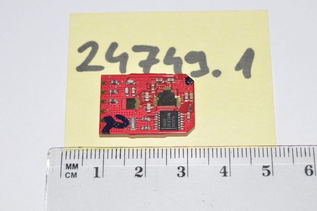 24749.1 szakszám
A jogosult nyilatkozata alapján a termék felületszerelt PCB, amely passzív és aktív elemeket tartalmaz. Passzív alkatrészek: kondenzátor, Ohmikus ellenállás; aktív alkatrész: fekete tokozásban lévő félvezető inverter. A PCB (nyomtatott áramkör) pozícióadó szenzorba kerül beépítésre (motor fő tengelypozíció, differenciálmű, féltengely pozíció). A fenti aktív és passzív elemek vastagréteg technológiával készültek (ellenállás, kondenzátor, inverter)
A PCB önmagában nem látja el a funkcióját. A szerelt termék a gépjármű kormánykerék forgatásakor, az elfordulási szöggel arányos jelet szolgáltat a kimeneten.  A PCB sem önmagában, sem szerelt állapotban nem rendelkezik mérő, vagy ellenőrző funkcióval, szerelt állapotban is csak hibajelet ad le. A funkció ellátásához szerelni kell további alkatrészeket. A termék automata szabályozóba kerül beépítésre. A termék meghatározza a szabályozandó jel értékét és átalakítja megfelelő elektromos jellé. A szerelt termék a gépjármű kormánykerék forgatásakor, az elfordulási szöggel arányos jelet szolgáltat a kimenetre. A termék kimeneti interfészét követően a szerelt végtermékről, működéséről nincsenek részletes információk.

A termék érzékszervi vizsgálata alapján: 16 x 23 x 1,6 mm méretű, téglavörös színű nyomtatott áramköri lap, melyen 1 db, kb. 4x5x1 mm téglatest alakú, 12 lábú, fekete műanyag tokozású áramköri elem (IC) és több kisebb felületszerelt (SMD) alkatrész került ráforrasztásra. A NYÁK lapon további 2 db téglalap alakú rézfelület került kialakításra, melyek körül érintkezők találhatóak és amelyekre további alkatrész kerülhet felszerelésre.

Az igazságügyi szakértői vélemény alapján a minta passzív és aktív alkatrészeket valamint nyomtatott áramköri lapot (NYÁK) tartalmazó termék. Az aktív komponens: egy egyszerűnek tekinthető inverter funkciót megvalósító integrált áramkör, ami lényegében egy erősítő, míg a passzív alkatrészek: ellenállás és kondenzátorok. A minta vélhetően a kormány elfordulását érzékelő egység alkatrésze. A minta szerelt áramköri elem, önmagában nyilvánvalóan nem használható, egy nagyobb funkcionális egység, a szervo motor része, de megállapítható, hogy a NYÁK-ra a specifikált aktív és passzív elemek mellett a kulcsfontosságú integrált áramközök nincsenek felszerelve. A termék tartalmaz integrált áramkört, de nem az. A termék tartalmaz nyomtatott áramkört (NYÁK), de nem az. A termék passzív és aktív elemeket tartalmaz, vastagréteg áramkör. Kizárólag egy meghatározott készülék, az ügyfél nyilatkozata alapján egy automata szabályozó (szervo motoros kormány) alkatrésze.