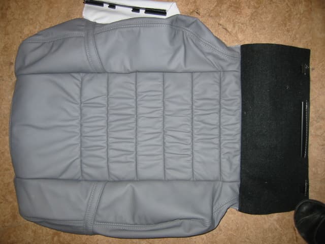 A PERMANENTLY FIXED REPLACEMENT AUTOMOTIVE CAR SEAT COVER. IT IS MADE OF LEATHER AND SYNTHETIC VINYL AND FITTED WITH FOAM PADDING. IT IS CUT AND SEWN TO SHAPE.
