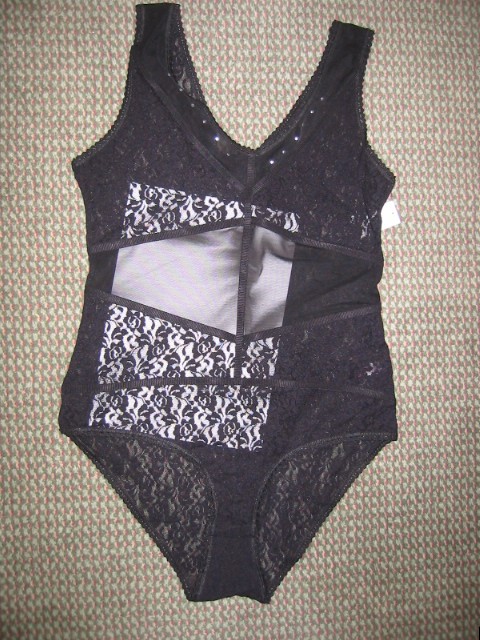 A KNITTED ALL-IN-ONE UNDERGARMENT FOR WOMEN; INTENDED TO COVER THE BODY REACHING DOWN TO THE CROTCH. V NECK; WITHOUT OPENING. WITHOUT SLEEVES. DOES NOT HAVE ADJUSTABLE SHOULDER STRAPS. ELASTICATED AT THE LEG AND ARM OPENINGS. THE CROTCH IS LINED AND HAS AN OPENING, WHICH IS FASTENED BY THREE PRESS STUDS. 92% NYLON AND 8% ELASTINE