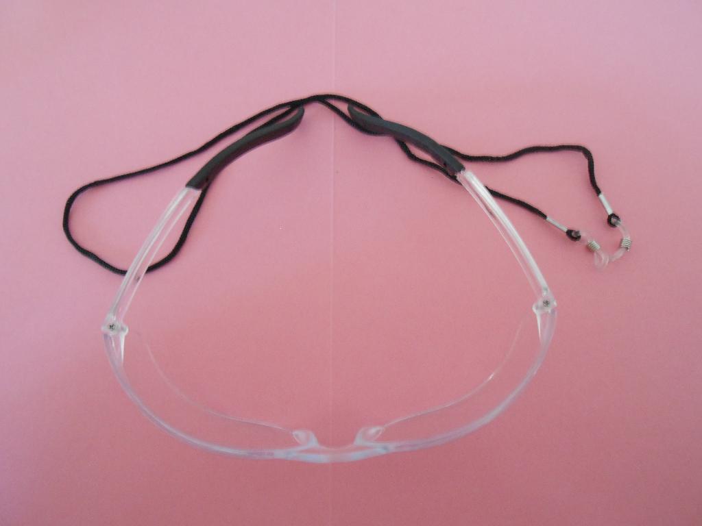 EYESHIELD/SAFETY GLASSES WITH ANTI-SCRATCH, CLEAR LENS AND BLACK RIM. LENS MADE FROM POLYCARBONATE. PACKAGED WITH LANYARD IN PLASTIC BAG