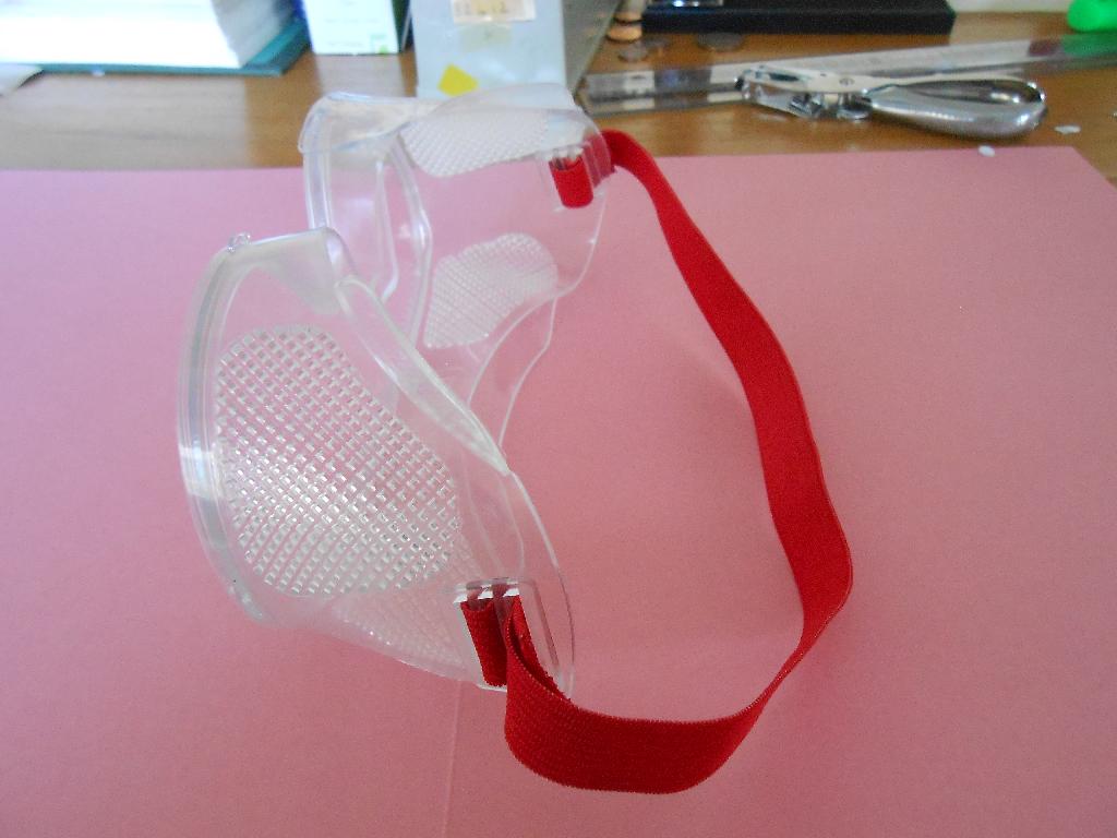 GOGGLE WITH LENS MADE FROM POLYCARBONATE. HAS A RED ELASTIC BAND TO SECURE ON THE HEAD