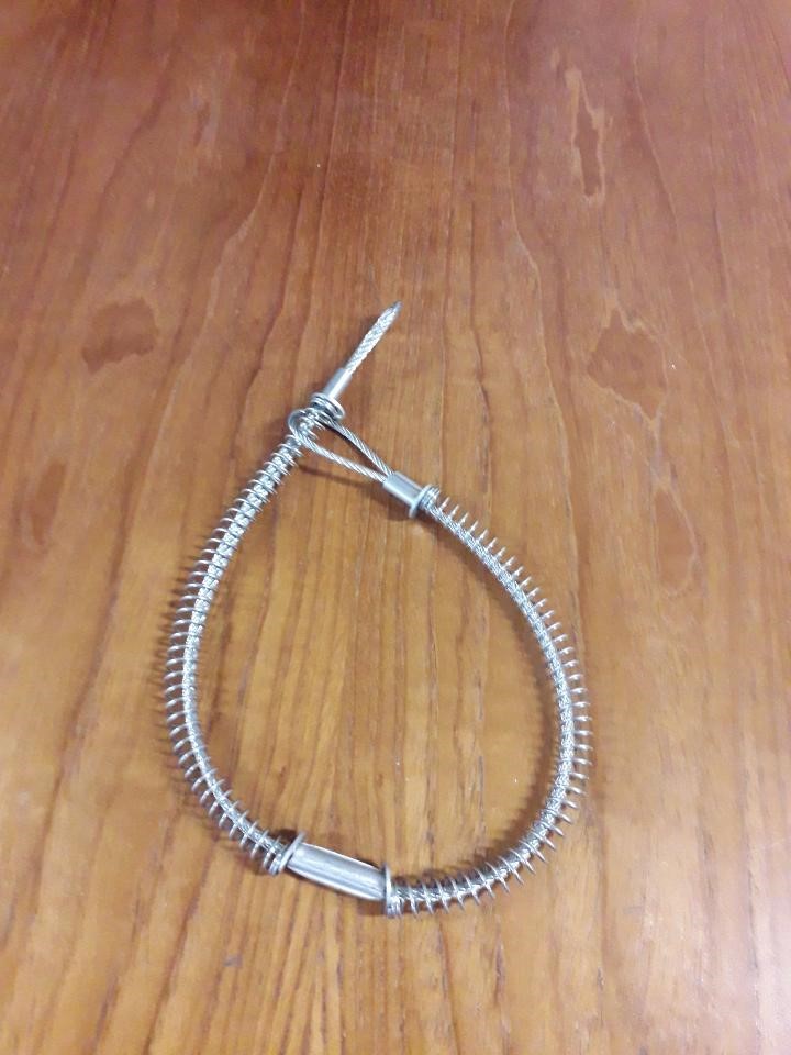 WHIPCHECK SAFETY CABLE FOR USE AS A SAFETY FEATURE TO ENSURE THAT IF AN END SHOULD BLOW OFF IT IS STILL ATTACHED TO THE HOSE.  THERE ARE LOOPS AT EITHER END AND A COIL SPRING AROUND MOST OF ITS LENGTH HELD IN PLACE BY WASHERS. THE LOOPS CONNECT TO EITHER SIDE OF A CONNECTION ON A PRESSURISED HOSE SYSTEM. IN THE EVENT OF THE CONNECTION FAILING UNDER PRESSURE AND THE HOSE COMES APART THEN THE CABLE WILL PREVENT THE HOSE FROM ‘WHIPPING’ WHICH COULD CAUSE INJURY OR DAMAGE. THE FUNCTION OF THE COIL SPRING IS TO ABSORB SOME OF THE PRESSURE CREATED BY THE PRESSURISED HOSE. DIAMETER OF CABLE 2.95mm AND APPROX. 555MM IN LENGTH