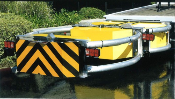 TRUCK MOUNTED ATTENUATOR (TMA). 

IT IS AN ELECTRO-MECHANICAL TRAFFIC SAFETY BARRIER. IT IS COMPRISED OF A STRUT AND CARTRIDGE SECTION ON A SUPPORT FRAME MADE FROM ALUMINIUM TUBE. THE CURVED SIDE RAILS PROVIDE PROTECTION AGAINST VEHICLES IMPACTING INTO THE REAR OF THE TRUCK (THE COFFIN CORNER AREA). IT IS EQUIPPED WITH REFLECTIVE MATERIAL AND WARNING LIGHTS.
THE TMA IS FITTED TO THE BACK OF A TRUCK AND IS LOWERED TO PROVIDE PROTECTION DURING ROADWORKS, VEHICLE REMOVAL ETC. IT IS DESIGNED TO HYDRAULICALLY FOLD UP AND OVER THE VEHICLE DURING TRANSPORT AND STORAGE.