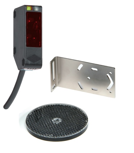 Reflective Active Infrared Switch for door activation. 

It is a long-range industrial door reflective light barrier with detection range of 12m. Optimal set-up indicated by a constantly illuminated yellow led. Water and dust proof. 

It operates on 12v to 240v DC or 24 to 240v AC.