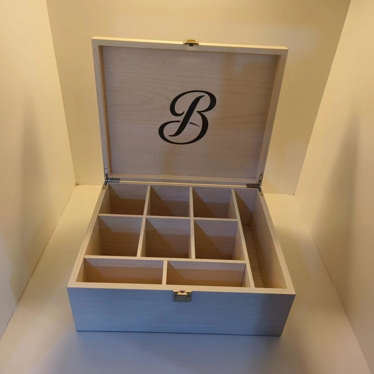 A box made of wood (MDF and oak veneer), fitted with metal hinges and a metal closure.  The box is to be used to hold tea bags. Box dimensions are 260*312*h85mm.