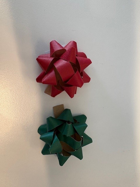 Decorative gift wrap bows made of paper tape forming several loops stitched to the small square paper tabs at the back. 16 bows packaged together for retail sale.
Paper