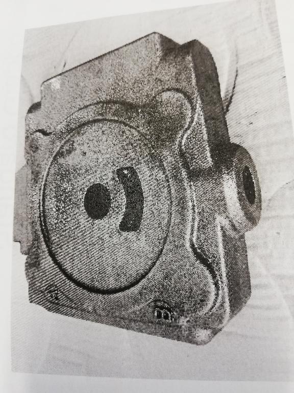 GETTO DI GHISA. 
L'ARTICOLO E' OTTENUTO COLANDO DIRETTAMENTE IL METALLO ALLO STATO LIQUIDO IN UNO SPECIFICO MODELLO/FORMA, LASCIANDOVELO POI SOLIDIFICARE E RAFFREDDARE. I CANALI PRESENTI ALL'INTERNO DEL PEZZO DI GHISA SI OTTENGONO ATTRAVERSO DELLE ANIME CHE SI POSIZIONANO ALL'INTERNO DEL MODELLO PRIMA DEL PROCESSO DI COLATA. IL GETTO FINALE SI PRESENTA COME UNA FUSIONE IN GHISA SFEROIDALE (MALLEABILE) DI FORMA RETTANGOLARE ED UN FORO CENTRALE; SU UN LATO SONO PRESENTI DUE FORI IDENTIFICATI CON LE LETTERE A E B; SU UN ALTRO LATO E' PRESENTE UN ULTERIORE FORO CHE COMUNICA CON L'APERTURA POSTA IN UNA DELLE DUE FACCE. SU UNA FACCIA DEL PEZZO E' PRESENTE UN CANALE DI FORMA CIRCOLARE. SU TUTTE LE SUPERIFICI DEL GETTO SONO PRESENTI SCANSI E SAGOMATURE.
L'ARTICOLO NECESSITA DI ULTERIORI LAVORAZIONI ED E' DESTINATO AL SETTORE DELL'INDUSTRIA OLEODINAMICA.