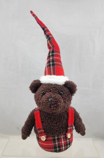 Manufatto tessile a maglia in poliestere, occhi e naso in acrilico, imbottito con ovatta, sabbia e resina di polietilene a forma di orsetto nella variante "Orso marrone con bretelle (dark brown bear)" della misura di circa 40 cm imballato singolarmente in una confezione trasparente (sacchetto).