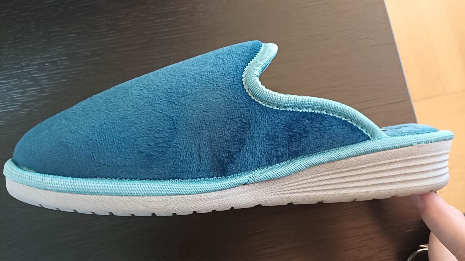 Ciabatta con tomaia in materiale tessile la cui suola è costituita da materiale tessile integrato con materiale polimerico. La superficie della suola, di colore grigio, presenta rilievi antiscivolo che vanno a contatto con il terreno. L’intersuola è costituita da materiale polimerico, non è removibile ed è foderata, nella parte a contatto con il piede, con materiale tessile.