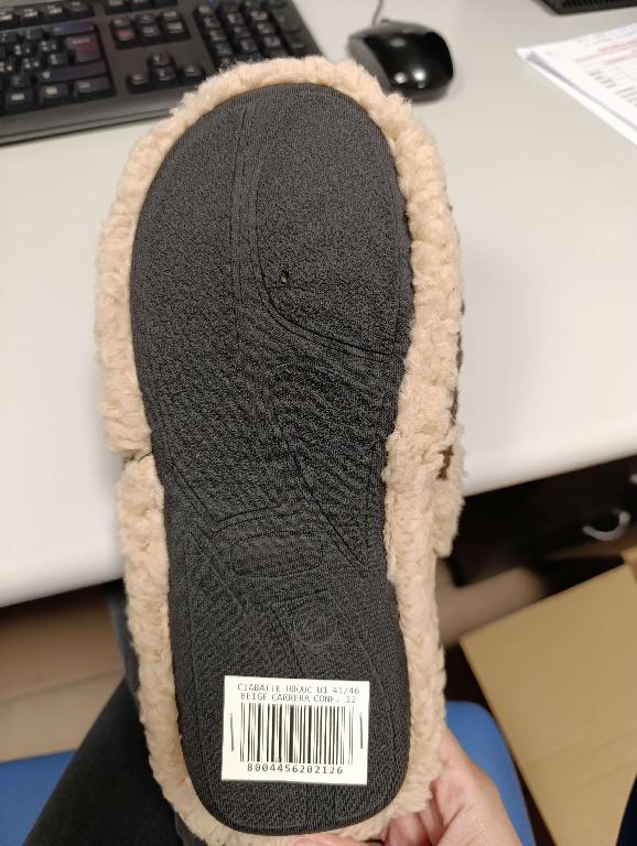 Pantofola con tomaia in materiale tessile, a maglia. Il prodotto presenta una finitura in materiale tessile effetto lana. La suola è composta da materiale tessile supportato da uno strato di gomma in cui è integrato in modo da non poter essere staccato.
L’intersuola è costituita da materiale polimerico, non è removibile ed è foderata dalla parte a contatto con il piede, con materiale tessile.