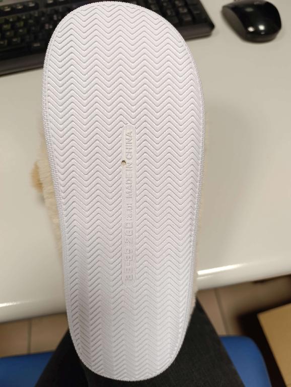 Pantofola con tomaia a maglia di colore crema ad effetto pelliccia, con applicazioni in tessuto e sottopiede in materiale tessile.
La suola è composta da materiale tessile supportato da uno strato di gomma in cui è integrato in modo da non poter essere staccato.
L’intersuola è costituita da materiale polimerico, non è removibile ed è foderata dalla parte a contatto con il piede con materiale tessile.