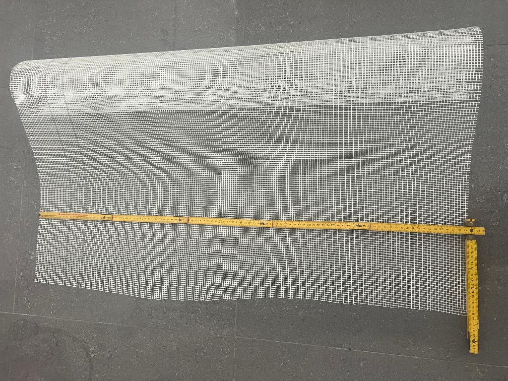 Tessuto in fibra di vetro in rotoli di 1 mt di altezza e 50 mt di lunghezza, con un peso di 168 gr/m2; presenta una maglia aperta di larghezza e lunghezza superiori a 1,8mm (apertura delle maglie 3,9 x 3,8 mm), in rotoli di 1 mt di altezza e 50 mt di lunghezza. Il prodotto rientra tra le stoffe legate meccanicamente in quanto realizzato su telaio per la fabbricazione di tessuti a maglia a giro inglese. Il tessuto durante il processo di fabbricazione, viene impregnato con SBR (Styrene butadiene rubber) attraverso immersione in vasche.
Secondo il dichiarato è utilizzato principalmente nel settore dell’edilizia per la realizzazione di cappotti termici rivestimento di facciate, riparazione di muri o altre simili applicazioni.