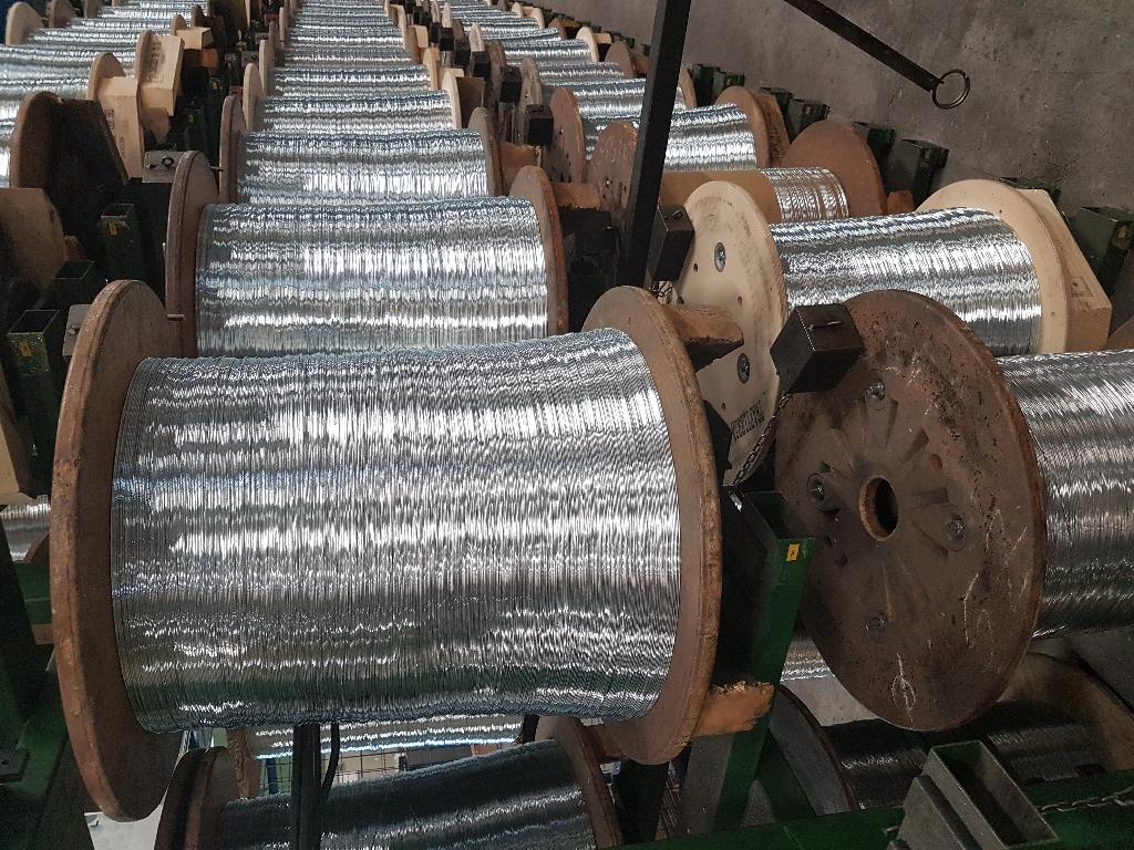 Banda in alluminio per la produzione di punti metallici.
La banda è composta da fili metallici di alluminio, del medesimo diametro, giustapposti ed incollati. 
La produzione della banda parte da un numero determinato di fili metallici, avvolti singolarmente in bobine, ottenuti da trafilatura a freddo di vergella.
Tutti i fili vengono svolti e incanalati in una linea di produzione (specifica per banda metallica) che comprende:
-	Raddrizzatore: insieme di rulli che raddrizzano eventuali curve dei fili
-	Laminatoio: per laminare i fili a misura 
-	espanditore di colla: per distribuire la colla sui fili che può essere neutra o colorata
-	forno asciugatore: per asciugare la colla 
-	trascinatore: per il traino della banda
-	avvolgitore: per avvolgere la banda ottenuta in apposite bobine
Al termine della lavorazione la banda metallica si presenta come un nastro di lamiera nella quale è possibile vedere la presenza dei fili giustapposti ed incollati. 
La banda così ottenuta si utilizza per ottenere per formatura, grazie all’azione di speciali presse, i punti metallici (graffe, spilli o groppini).