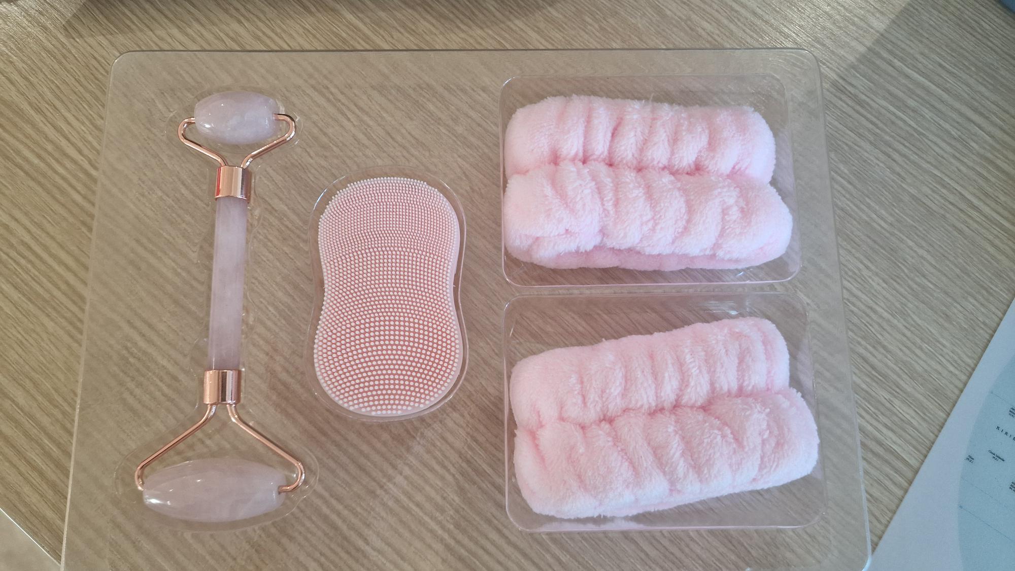 Set per la cura del viso (skincare), composto da diversi articoli destinati ad essere utilizzati congiuntamente nelle operazioni di applicazione e detersione dei prodotti cosmetici.
Il set comprende:
un face roller, accessorio cosmetico costituito da una struttura in metallo con rullo in quarzo rosa, destinato all’applicazione di prodotti skincare;
uno scrubber viso, accessorio per la detersione realizzato in silicone, dotato di superficie a micro‑punte;
due polsini in tessuto non a maglia (85% poliestere e 15% poliammide), utilizzati per evitare che l’acqua scenda lungo le braccia durante la detersione del viso.

I componenti sono:
complementari tra loro
destinati ad essere utilizzati congiuntamente nell’ambito della routine di cura del viso

L’insieme è:
presentato in un’unica confezione
confezionato per la vendita al dettaglio
commercializzato come set unico