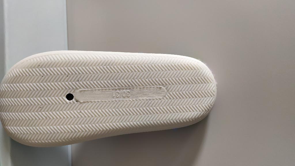 Pantofola da camera per uso domestico, realizzata con tomaia interamente in materiale tessile, disponibile in varianti a tinta unita o fantasia, anche nella versione a punta aperta.
La suola esterna è costituita da materiale tessile, che rappresenta il componente strutturale principale della suola stessa e non un semplice rivestimento o rinforzo.
La superficie della suola è dotata di rilievi antiscivolo applicati i quali hanno una funzione accessoria di miglioramento dell’aderenza ma non alterano la natura tessile predominante della suola esterna.