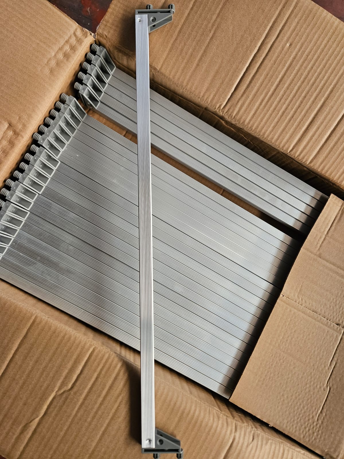 Catenaria in alluminio con terminali in plastica
Il prodotto è una catenaria costituita da un elemento principale in alluminio e da due terminali in plastica, presentata in diverse lunghezze predeterminate (263, 300, 413, 563, 600, 613, 713, 800, 863, 1013, 1163, 1363 e 1463 mm).
Il corpo principale è formato da un profilo cavo in alluminio, di tipo “millerighe”, tagliato a misura in funzione delle dimensioni dei mobili cui è destinato. Alle due estremità del profilo metallico sono applicati terminali in plastica, ciascuno dotato di due protuberanze cilindriche. I terminali sono fissati al corpo in alluminio mediante punzonatura, operazione che rende le componenti in plastica e il corpo metallico un insieme unico e inscindibile; i terminali non sono removibili senza distruzione del prodotto.
La catenaria è utilizzata come elemento strutturale di fissaggio per i mobili base da cucina. La sua funzione è quella di collegare tra loro due fianchi in legno del mobile, posizionati uno di fronte all’altro. Il collegamento avviene tramite l’inserimento delle protuberanze cilindriche dei terminali in plastica nei fori appositamente predisposti nei fianchi del mobile; successivamente, i fianchi vengono battuti in corrispondenza delle protuberanze al fine di rafforzare l’incastro.
Per forma, dimensioni e modalità di fabbricazione, il prodotto è destinato esclusivamente all’impiego come elemento di montaggio e fissaggio per mobili, dei quali costituisce parte componente essenziale, non risultando idoneo a utilizzi diversi.