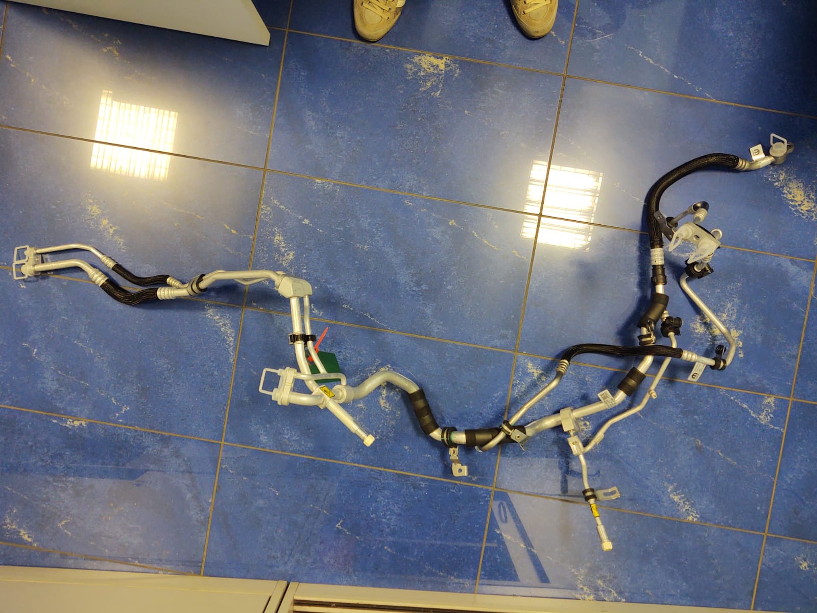 SISTEMA DI VALVOLE DI NON RITORNO ASSEMBLATE SU TUBI.
L’ARTICOLO HA UNA LUNGHEZZA DI CIRCA 150 CM ED E’ COMPOSTO DA TUBI IN GOMMA, ALLUMINIO E ACCIAIO.
SECONDO QUANTO DICHIARATO, LE PARTI COSTITUTIVE CORRISPONDONO ALLE SEGUENTI SPECIFICHE: UN COMPONENTE COMPOSTO DA
DUE VALVOLE DI RITEGNO IN ALLUMINIO SALDATE AI TUBI NECESSARI PER IL COLLEGAMENTO TRA IL CONDENSATORE E
L’INSTALLAZIONE NELL’IMPIANTO DI CONDIZIONAMENTO E LA VALVOLA DI ESPANSIONE POSTA SULL’AUTOVETTURA (LA VALVOLA DI
ESPANSIONE NON E’ OGGETTO DELLA PRESENTE ITV); UN TUBO IN GOMMA, ALLUMINIO E ACCIAIO NECESSARIO PER IL
COLLEGAMENTO DEL COMPRESSORE E DEL CONDENSATORE SULL’IMPIANTO DI CONDIZIONAMENTO; TUBO IN GOMMA E ACCIAIO
COMPLETO DI ELEMENTO DI CONGIUNZIONE RAPIDA IN PLASTICA; UNA VALVOLA DI RITEGNO IN ALLUMINIO, SALDATA SU UN
INSIEME DI TUBI ACCESSORI, AVENTE LA FUNZIONE DI CONSENTIRE LA RICARICA DELL’IMPIANTO DI CONDIZIONAMENTO DI GAS FREON (COSTITUISCE LA PARTE CENTRALE DEL PRODOTTO); DOPPIA TUBAZIONE IN GOMMA E ALLUMINIO AVENTE LA FUNZIONE
FINALE DI COLLEGAMENTO TRA L’IMPIANTO DI CONDIZIONAMENTO E IL CHILLER DI RAFFREDDAMENTO DELLE BATTERIE
(QUEST’ULTIMO COMPONENTE PER LA VERSIONE IBRIDA).
L’ARTICOLO RAPPRESENTA IL CIRCUITO FONDAMENTALE PER IL PASSAGGIO DEL FLUIDO REFRIGERANTE ALL’INTERNO DELL’IMPIANTO
DI CONDIZIONAMENTO DI UNA SPECIFICA AUTOVETTURA.
LA MERCE SI PRESENTA SMONTATA PER ESIGENZE DI TRASPORTO E DI OTTIMIZZAZIONE DEGLI INGOMBRI DURATE IL TRASPORTO.
