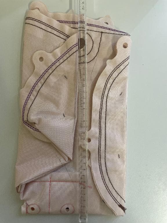 Componente di un sistema airbag per auto consistente in un cuscino gonfiabile di sicurezza che si presenta piatto e piegato su 3 lati  con una larghezza da piegato di 13 cm x 34 cm . Il cuscino aperto assume una forma irregolare simile ad un ovale. L’articolo è  composto da tessuti di fibra poliammidica di colore rosa ad alta resistenza cuciti tra loro.