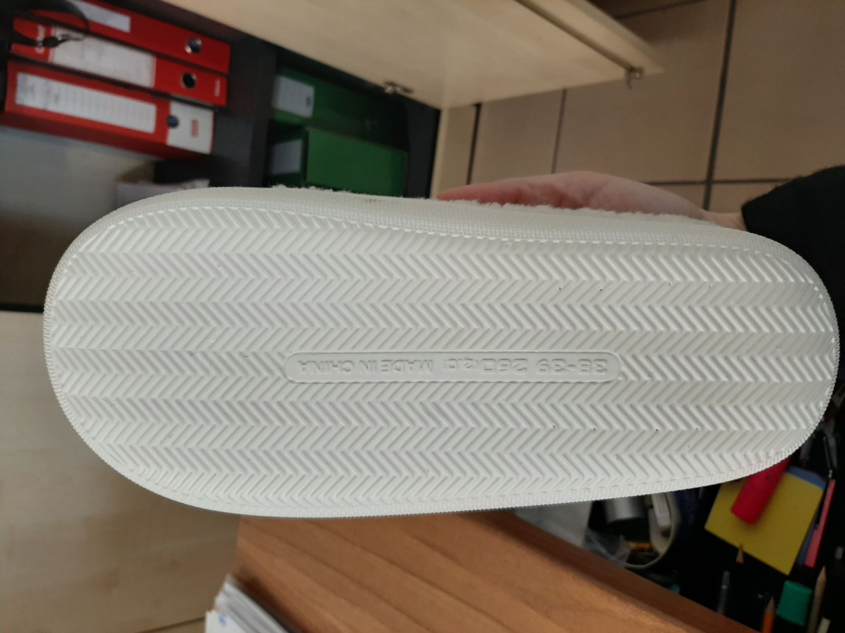 PANTOFOLA  DA DONNA.
LA TOMAIA E' LEGGERMENTE IMBOTTITA E RISULTA COSTITUITA PREVALENTEMENTE DA MATERIALE TESSILE (POLIESTERE) A MAGLIA RICCIA. NELLA PARTE CENTRALE SUPERIORE  PRESENTA UN INSERTO IN TESSUTO PLASTIFICATO. LA SUPERFICIE DELLA SUOLA ESTERNA PRESENTA RILIEVI ANTISCIVOLO ED E' COSTITUITA DA UNO STRATO DI GOMMA. L'INTERSUOLA, COSTITUITA DA MATERIALE POLIMERICO, NON E' REMOVIBILE ED E' FODERATA NELLA PARTE A CONTATTO CON IL PIEDE, CON MATERIA TESSILE.