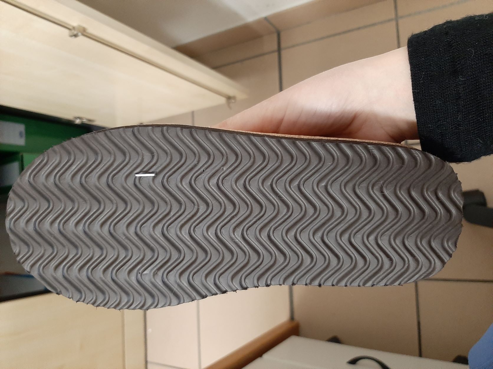 PANTOFOLA CHIUSA DA DONNA. LA TOMAIA E' COSTITUITA DA MATERIALE TESSILE COLOR AVANA, EFFETTO SCAMOSCIATO.. LA SUPERFICIE DELLA SUOLA ESTERNA PRESENTA RILIEVI ANTISCIVOLO ED E' COSTITUITA PRINCIPALMENTE DA UNO STRATO DI GOMMA TERMOPLASTICA IN CUI E' PRESENTE COME RINFORZO UN ELEMENTO TESSILE. L'INTERSUOLA NON E' REMOVIBILE, E' COSTITUITA DA MATERIALE POLIMERICO ED E' FODERATA DALLA PARTE A CONTATTO CON IL PIEDE CON MATERIALE TESSILE.