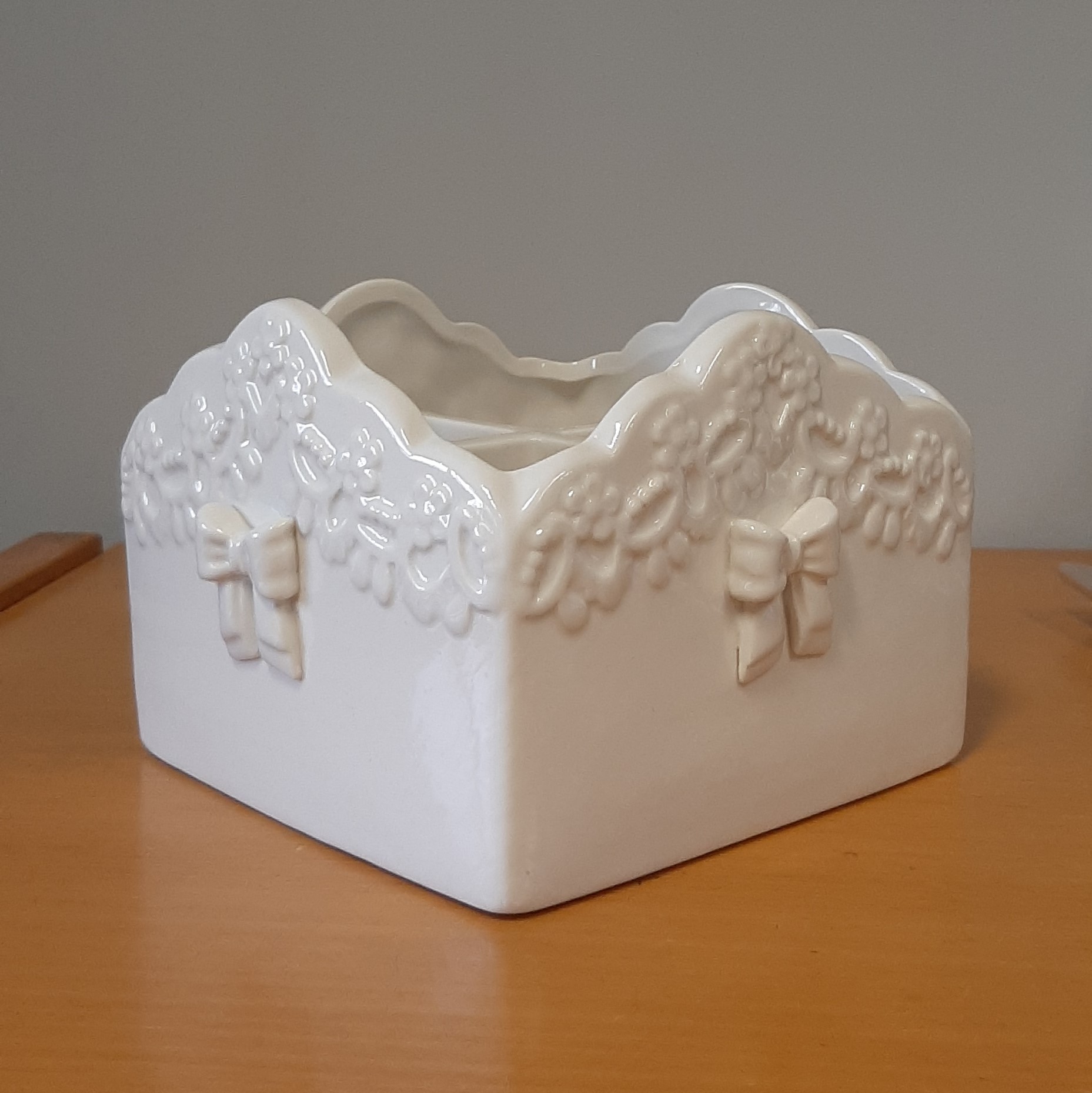 Porta posate in ceramica di colore bianco, di forma quadrata, con decorazioni in rilievo sulla parte esterna.
L'articolo misura circa cm 15 x 15 x 11.
Il carattere ornamentale non predomina sulla funzione utilitaria dell'articolo che è destinato a contenere delle posate.
Il prodotto si presenta condizionato per la vendita al minuto avvolto in pluriball e confezionato in una scatola di cartone bianca.