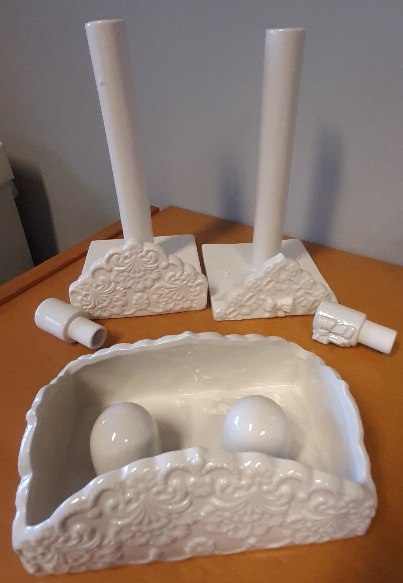 Porta rotolo in ceramica di colore bianco, con base di forma quadrata di lato circa 14 cm e supporto cilindrico di altezza circa 25 cm nella cui cavità si inserisce un terminale di circa 7 cm. L'articolo presenta nella parte esterna decorazioni in rilievo.
Il carattere ornamentale non predomina sulla funzione utilitaria dell'articolo che è destinato a portare rotoli di carta assorbente.
Il prodotto si presenta condizionato per la vendita al minuto con idonea protezione di polistirolo e confezionato in una scatola di cartone bianca.