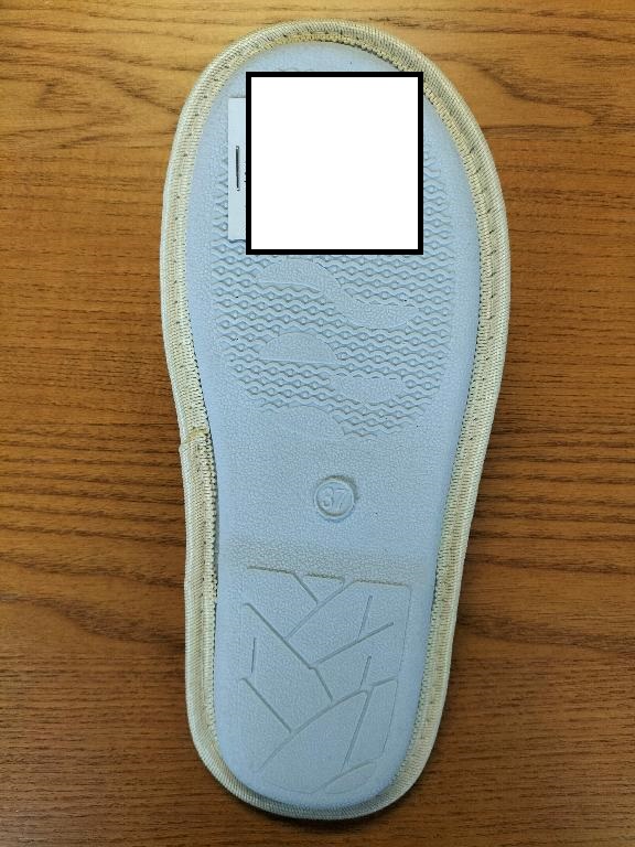 Pantofola da donna.
La tomaia monocolore  è in materiale tessile simil-velluto e presenta delle scritte ricamate mediante cucitura. La suola esterna presenta rilievi antiscivolo ed è costituita interamente da gomma.
L’intersuola, costituita da materiale polimerico, non è removibile ed è foderata dalla parte a contatto con il piede, con materiale tessile.