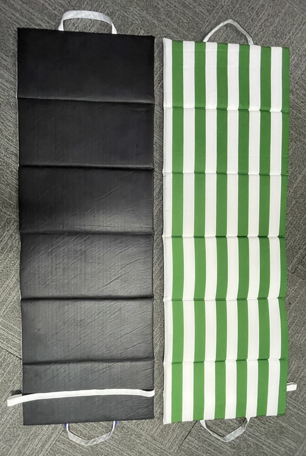 Materassino pieghevole con maniglie per agevolarne il trasporto ed una fascia elastica per permetterne la chiusura. È progettato per essere usato all’esterno, appoggiato al suolo, e per essere facilmente richiuso e trasportato. La parte anteriore è in tessuto non a maglia in 100% poliestere, il retro in polietilene, e l’interno è imbottito con spugna di poliuretano.  La parte anteriore e quella posteriore in poliuretano sono tenute assieme mediante una cucitura lungo i bordi.