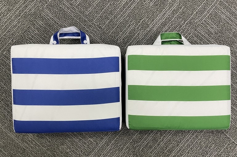 Cuscino pieghevole per sedie, dotato di maniglie per essere facilmente trasportabile. Il cuscino non è autoportante. Il tessuto esterno del cuscino è in 100% poliestere, e presenta un’imbottitura interna in spugna di poliuretano.