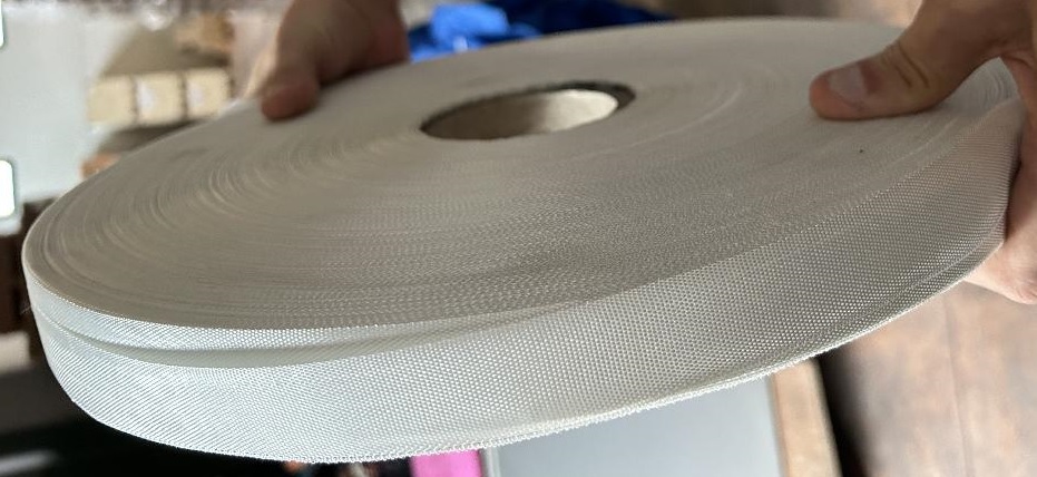 Nastro di tessuto legato meccanicamente costituito da filati tessili di fibre di vetro continue, ritorte, a maglia chiusa, ad armatura a tela.
Il tessuto non è rivestito né stratificato.
L'articolo è destinato ad essere utilizzato per il rivestimento dei cavi.
La merce si presenta in rotoli di colore bianco di altezze varie, da 15 mm a 50 mm. 
In base all'utilizzo, può essere fornito con spessori differenti:
1) 0,13 mm - massa areica 160 g/m2 - torsione del filato 45 giri al metro circa;
2) 0,14 mm - massa areica 180 g/m2 - torsione del filato 28 giri al metro circa;
3) 0,18 mm - massa areica 210 g/m2 - torsione del filato 28 giri al metro circa.