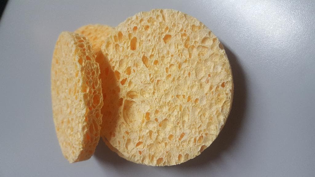 Articolo per l'igiene o la toletta.
L'articolo  è un dischetto di spugna alveolare di colore giallo ottenuta a partire da cellulosa.