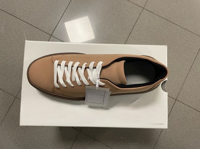 Calzatura da uomo, con tomaia in cuoio ricostituito di colore beige e suola esterna in materia plastica/gomma.

La calzatura ha una misura della suola interna superiore ai 24 cm e non ricopre la caviglia, la mascherina non presenta intagli. Sistema di chiusura a lacci tradizionale. Non è presente il puntale protettivo.