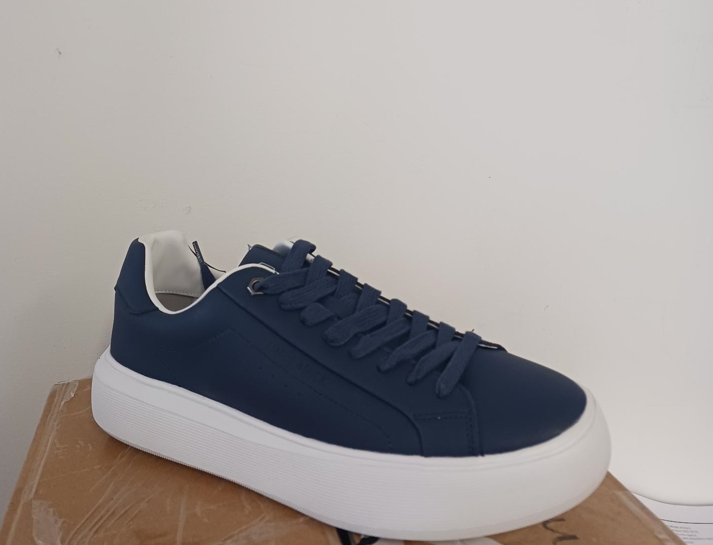 Calzatura da uomo, con tomaia in cuoio ricostituito di colore blu e suola esterna in materia plastica/gomma.

La calzatura ha una misura della suola interna superiore ai 24 cm e non ricopre la caviglia, la mascherina non presenta intagli. Sistema di chiusura a lacci tradizionale. Non è presente il puntale protettivo.