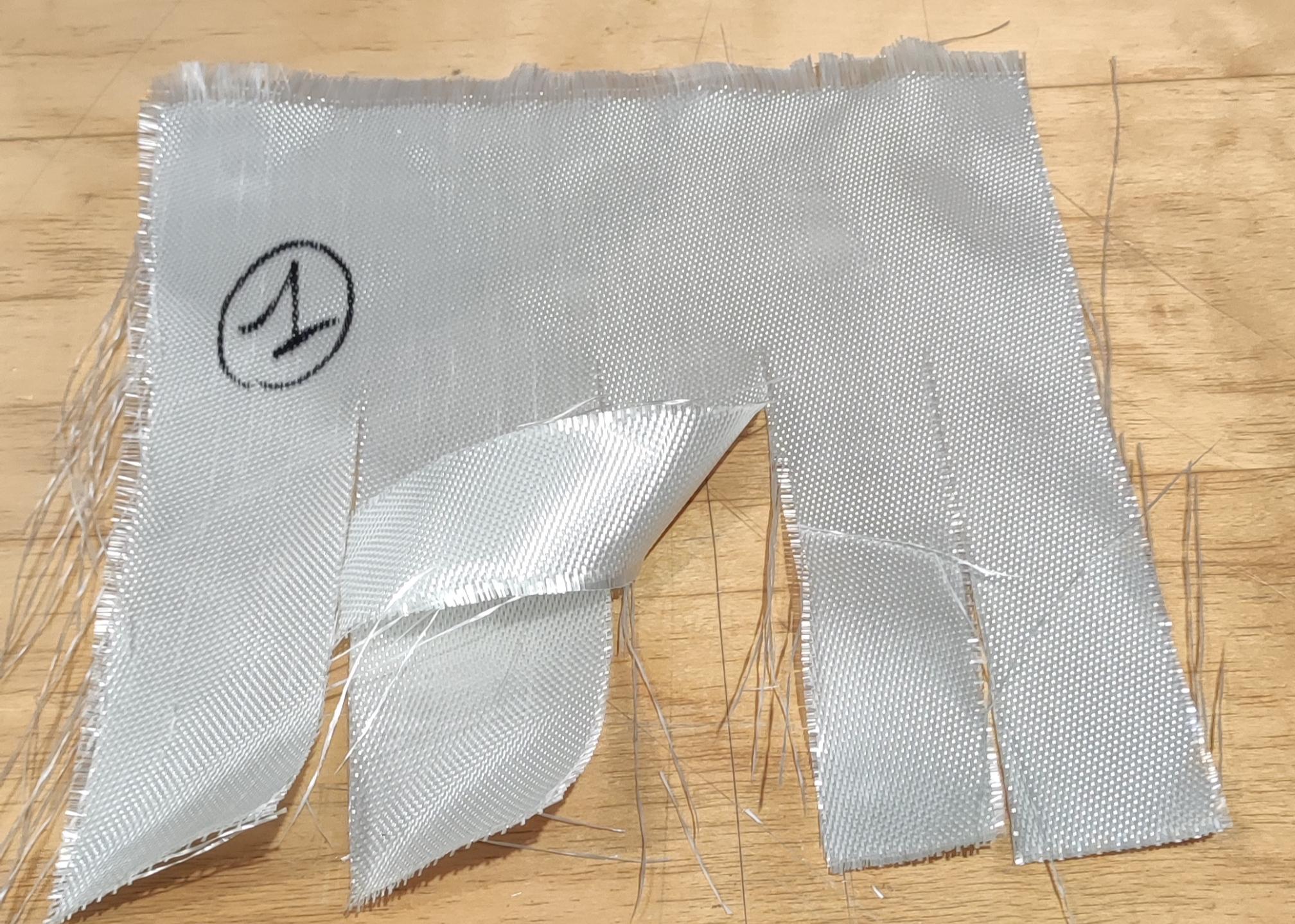 Tessuto in fibre di vetro, continue, ritorte, a maglia chiusa, ad armatura a raso di 5, con diametro medio delle fibre di vetro di 12μm, e massa areica di 668 g/m².
Il tessuto è spalmato su un lato con materiale polimerico (Poliuretano) di colore grigio.
Il tessuto è per dichiarazione di parte, impiegato nella costruzione di materassini isolanti per l'isolamento  dei vani motore  nei settori  Automotive e Nautico.
L'articolo si presenta in rotoli.