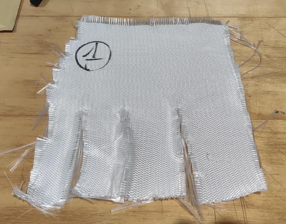 Tessuto in fibre di vetro, continue, ritorte, a maglia chiusa, ad armatura a raso di 4, con diametro medio delle fibre di vetro di 10μm, e massa areica di 499 g/m².
Il tessuto è spalmato su un lato con materiale polimerico (Polidimetilsilossano) di colore grigio.
Per dichiarazione di parte, il tessuto è  impiegato nella costruzione di materassini isolanti  nei settori Automotive e Nautico.
L'articolo si presenta in rotoli.