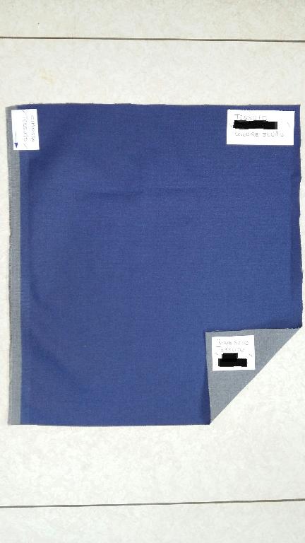 TESSUTO STAMPATO CON ALMENO 85% DI COTONE E CON PESO SUPERIORE A 200 GR/MQ CON TRAMA SAIA 2.2. AD ARMATURA DIAGONALE. IL TESSUTO E’ DI COLORE GRIGIO, STAMPATO DI COLORE BLU O MARRONE IN TINTA UNITA SUL DRITTO. LA PARTE COLORATA E’ GOMMATA AL TATTO E LA TRAMA RIMANE CHIARAMENTE PERCETTIBILE AD OCCHIO NUDO.