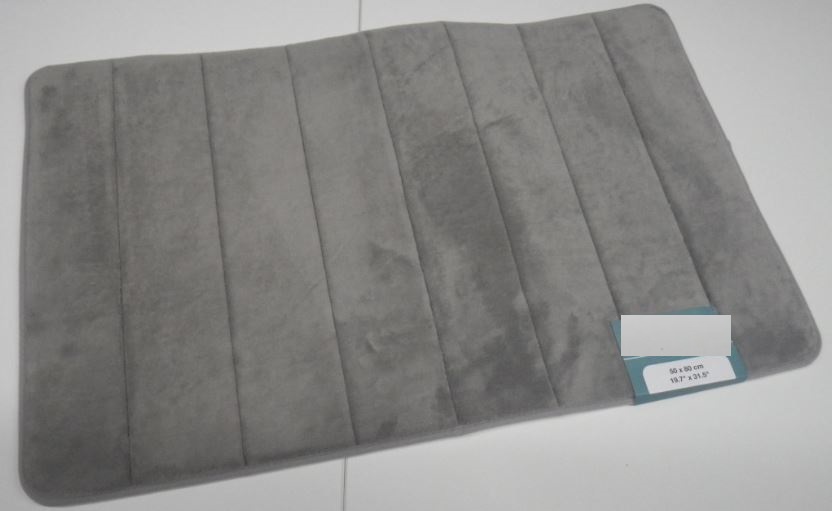 Taisnstūra formas paklājs, kas atbilstoši pieteicēja norādītājai informācijai ir paredzēts lietošanai vannas istabā. Izmēri 50 x 80 cm. Paklāju veido trīs kārtas: 
- virspuse ir no plūksnotas trikotāžas drānas, kas izgatavota no poliestera;
- pamatne ir no polivinilhlorīda tīklveida loksnes;
- vidusdaļā ir porolona slānis.
Malas ir apšūtas ar šauru lenti. Nav roku darbs.