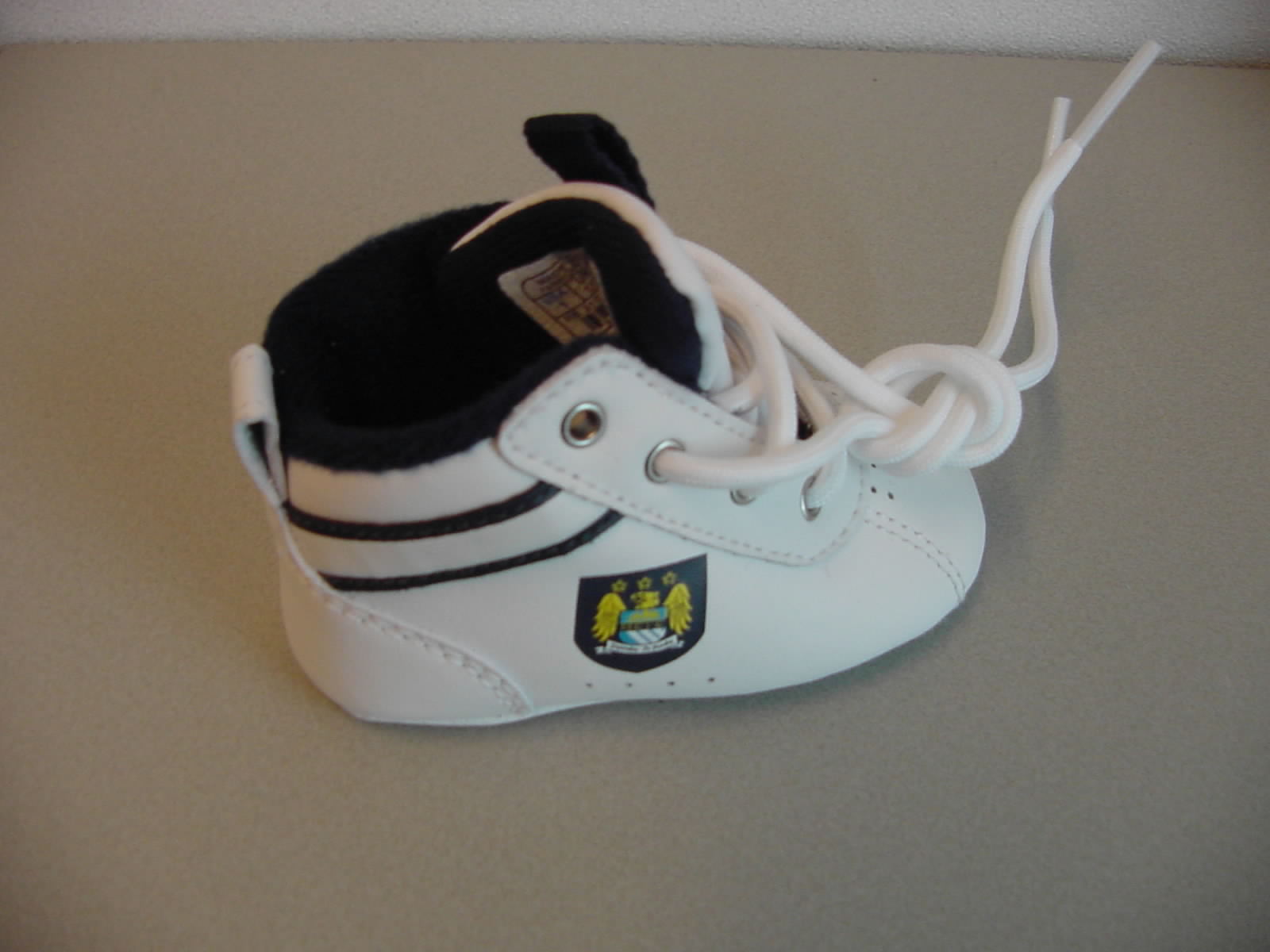 Huisschoeisel voor baby's geheel van leder met de volgende kenmerken:
- de enkel bedekkend;
- voorzien van vetersluiting;
- een tong van kunststof waarop een lint van textiel is gestikt dat uitmondt in een lus;
- op de hiel een aantreklus van leder;
- aan de buitenzijde en op de wreef zijn ventilatie gaatjes aangebracht;
- aan weerzijde van de schoen een decoratieve strip;
- heeft een uitneembaar binnenzooltje;
- aan de buitenzijde van de schoen en op het buitenzooltje staat een applicatie afgebeeld;
- op het buitenzooltje staat de naam en logo afgebeeld.