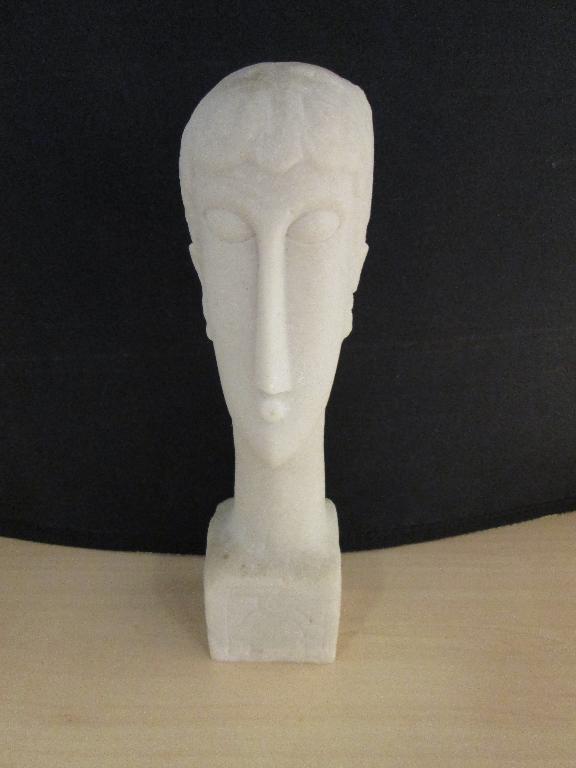 Een beeld van een langwerpig hoofd op een voetstuk met onder andere de volgende kenmerken:
- een siervoorwerp;
- vervaardigd van kunststof en calciumcarbonaat;
- niet keramisch gebakken.
Het beeld is verpakt in polystyreen in een kartonnen doos.